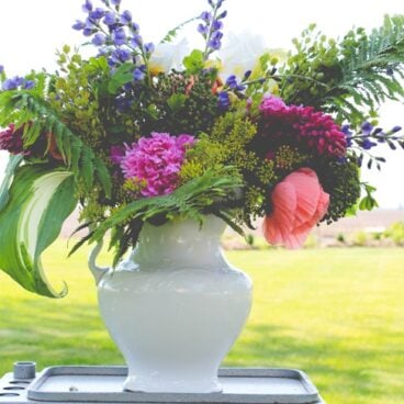 Finished rustic arrangement with lots of different flowers from the garden in an ironstone container during the summer season.