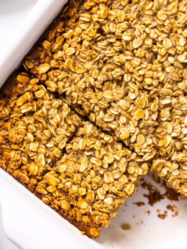 Top down view of white baking dish filled with baked oatmeal with golden crust all on white countertop