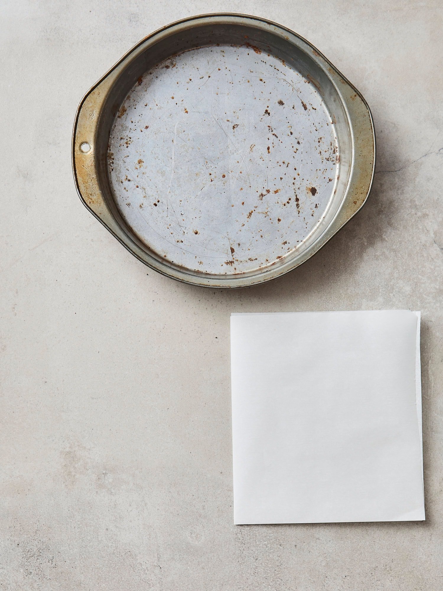 Cake pan with half piece of parchment folded.