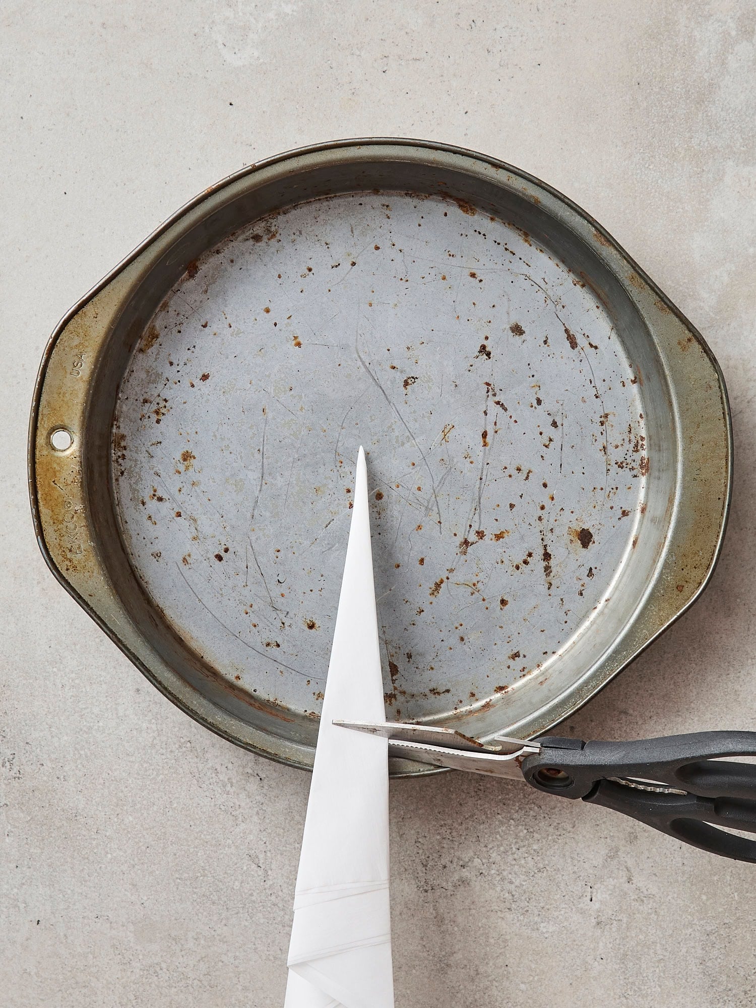 Cake pan with scissors about to cut.