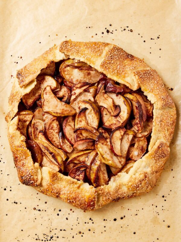 Fully baked apple galette sitting on a piece of parchment paper.