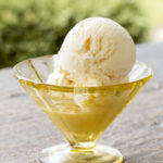 A scoop of vanilla ice cream in a dish.