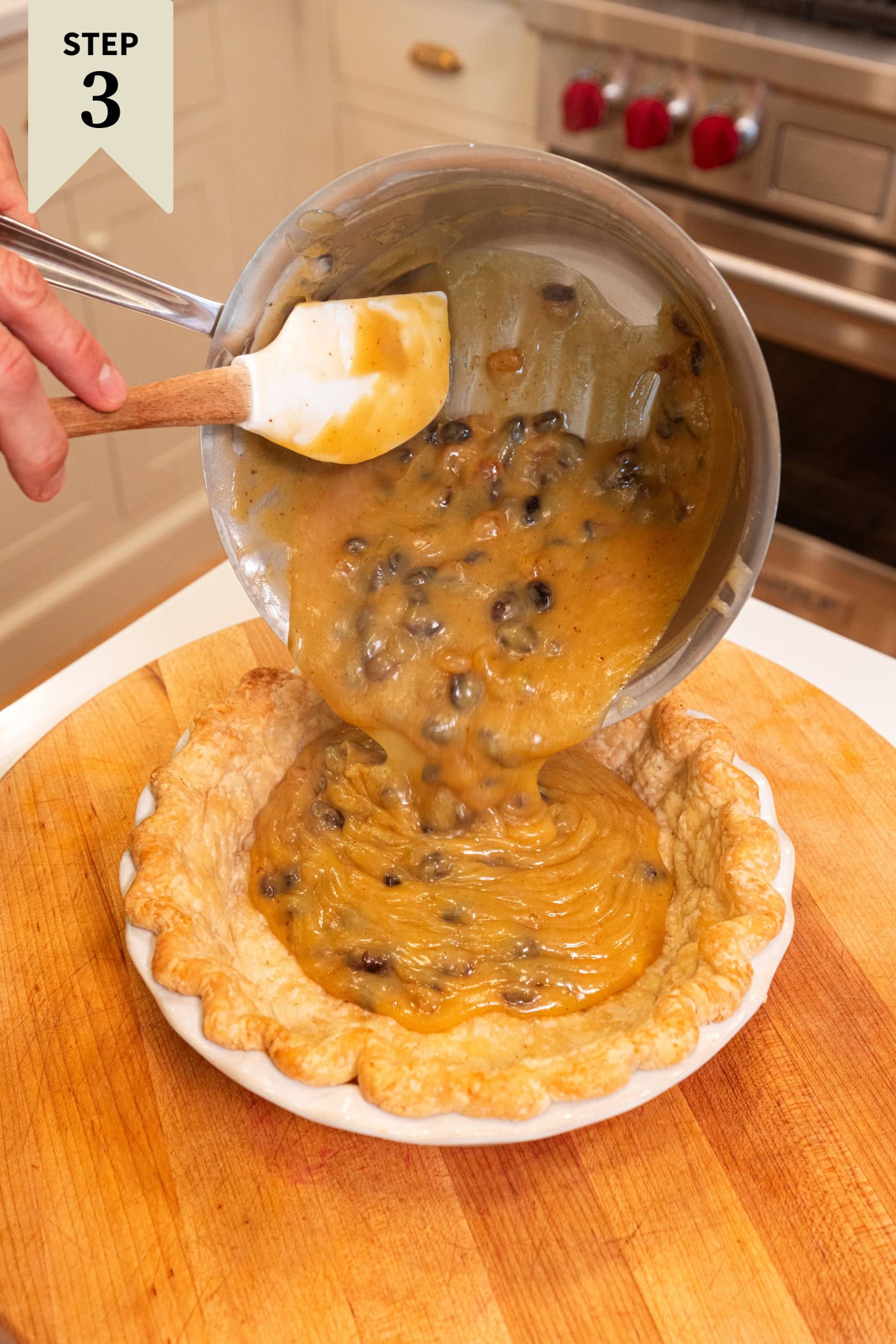 Pie shell with custard filling being pour into it from a metal saucepan.