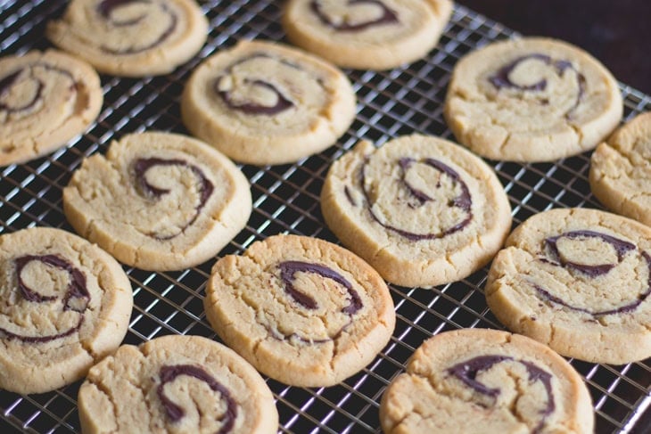 Peanut butter rollup cookies sitting on cooling rack after coming out of the oven.