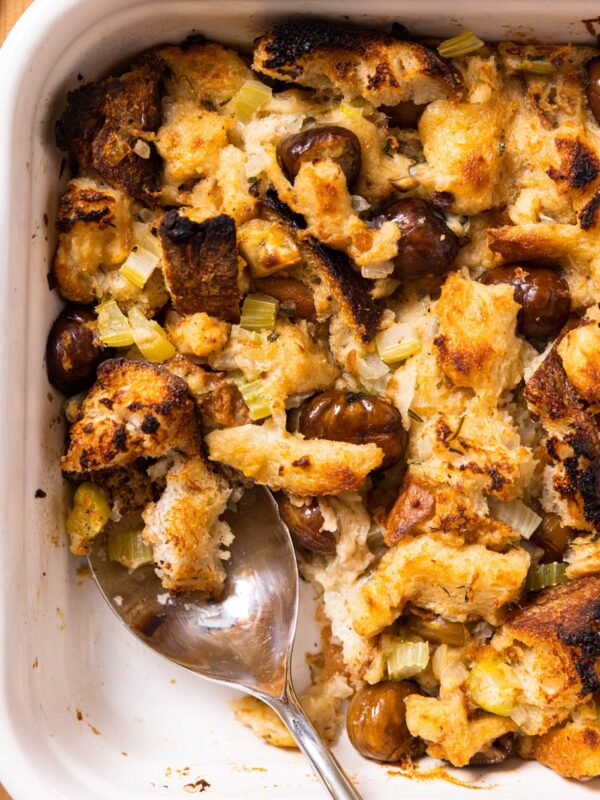 Top down view of white baking dish filled with slow cooker stuffing that is crispy on the top and topped with chestnuts