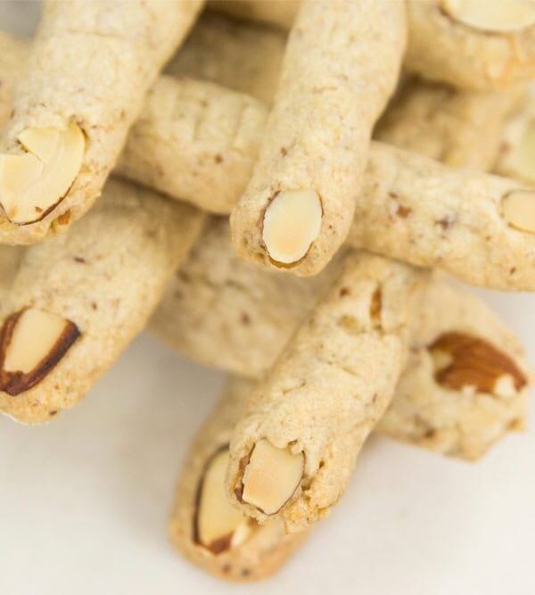 Criss crossed finger cookies made in a finger shape with an almond as a nail.