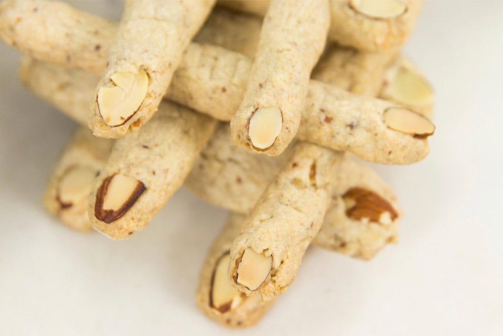 Criss crossed finger cookies made in a finger shape with an almond as a nail.