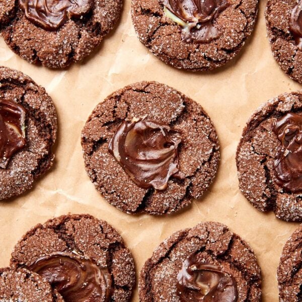 Piece of parchment with chocolate mint cookies with mint spread on top.