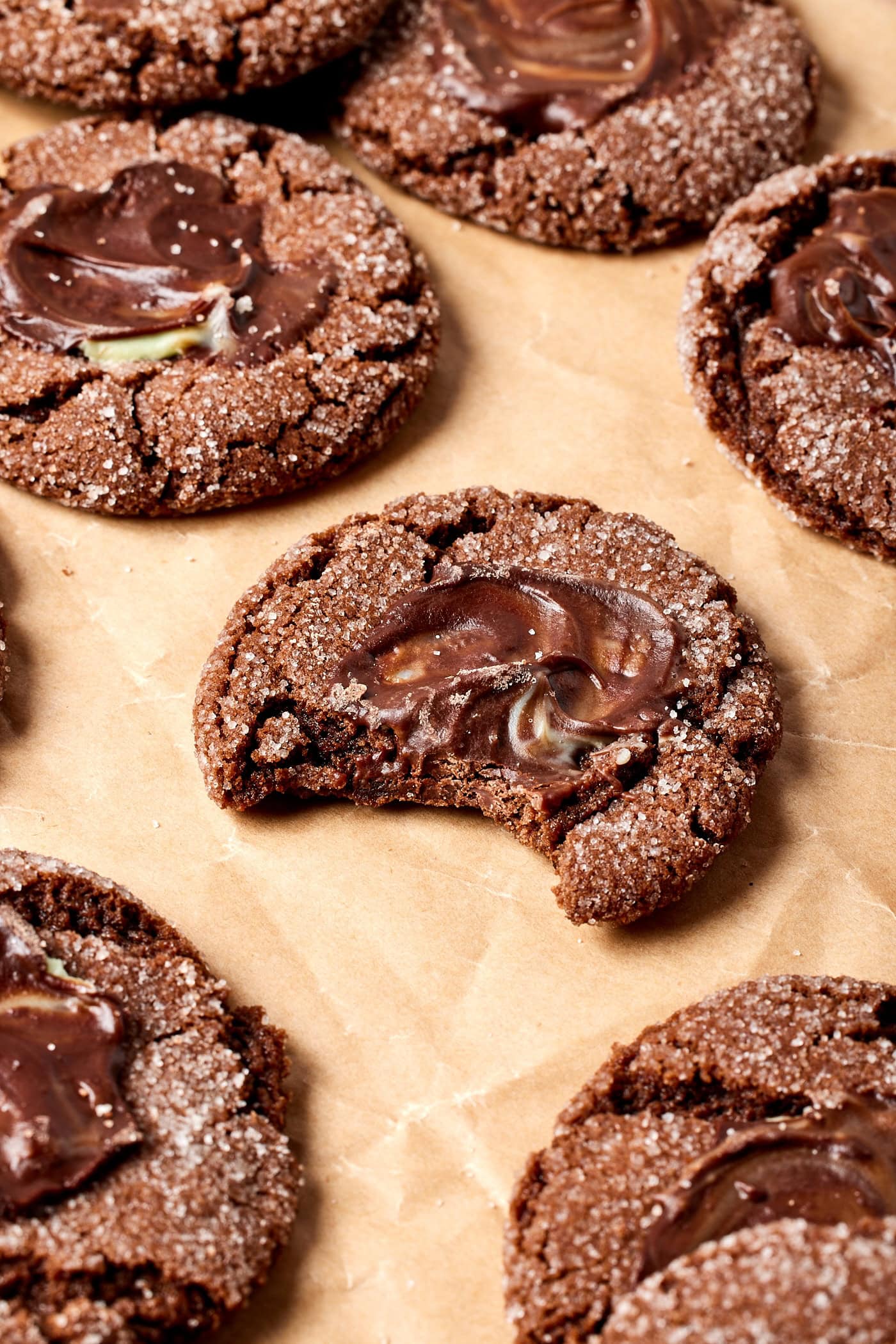 Chocolate mint cookie sitting on piece of parchment with bite taken out.