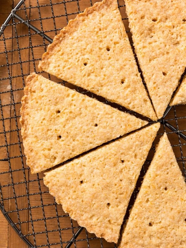 Top down view of golden colored cookies sitting on wire cooling rack all on wood surface