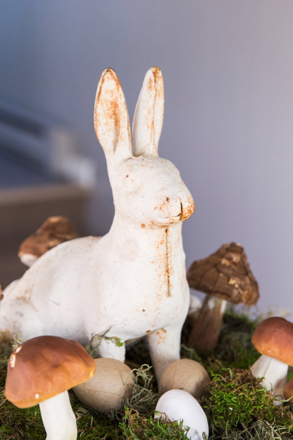 Cast iron white bunny sitting amongst mushrooms with moss in a large bowl for display at Easter.