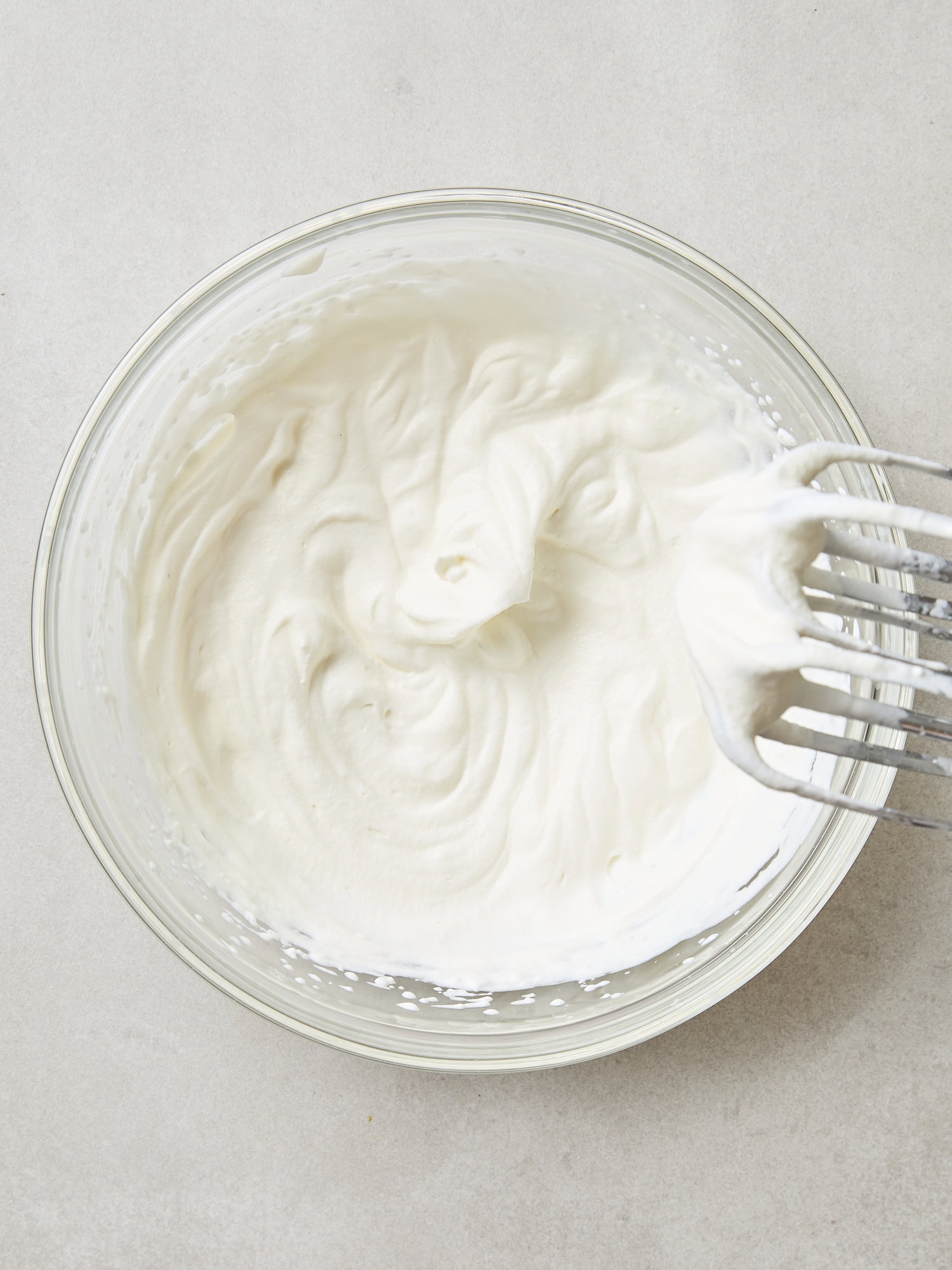 Glass bowl filled with whipped heavy cream.