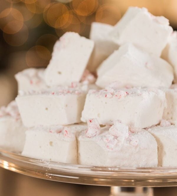 Glass platter filled with a stack of white and red colored peppermint marshmallows for the holiday season.