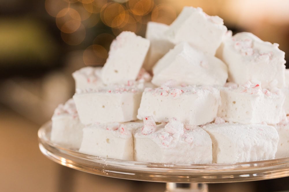 Glass platter filled with a stack of white and red colored peppermint marshmallows for the holiday season.