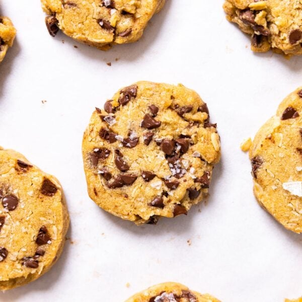 Top down view of baked chocolate chip and oatmeal refrigerator cookies sitting on white piece of parchment