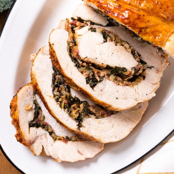 Top down view of slices of turkey roulade laying on white plate