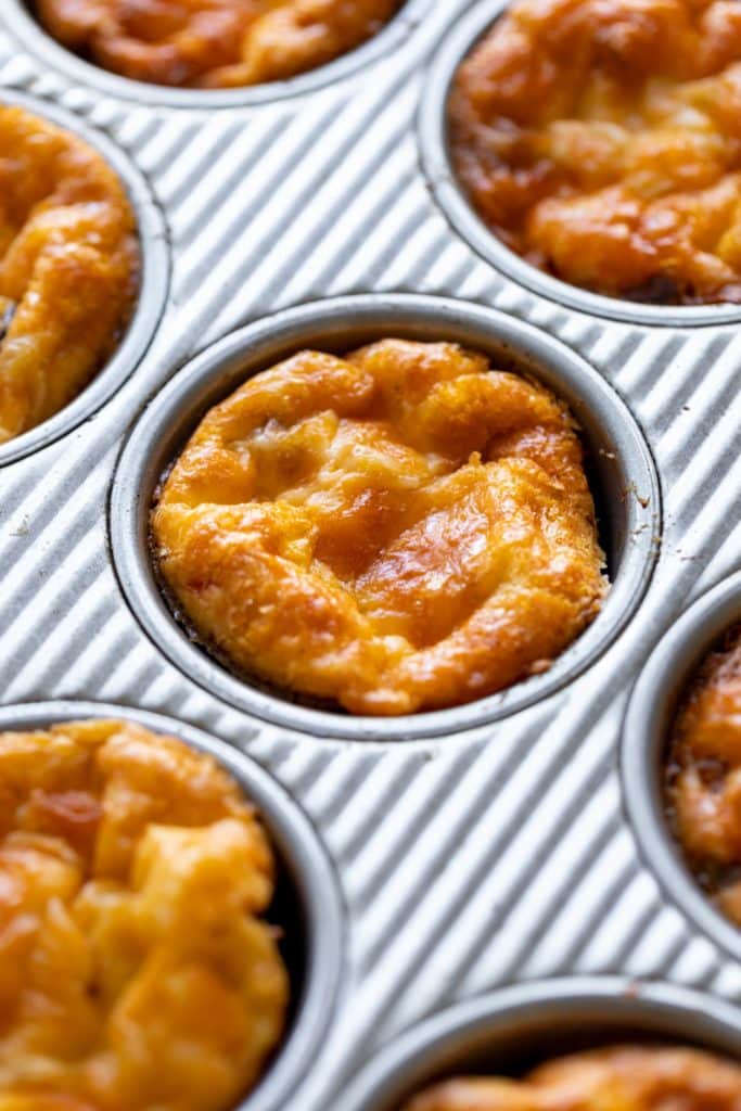 Golden brown baked huevos rancheros egg cups sitting in silver baking dish