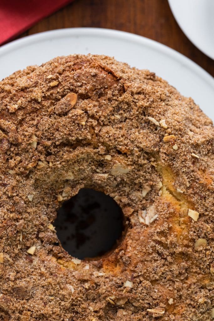 Top down view of streusel topping on top of a coffee cake with hole down the center with red napkin in background