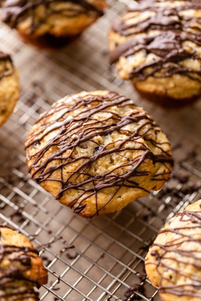 Top down view of banana muffins drizzled with chocolate sitting on wire cooling rack