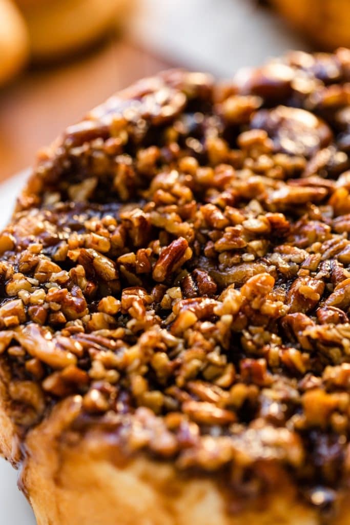Sticky caramel roll recipe topped with chopped pecans and drizzled with a caramel sauce