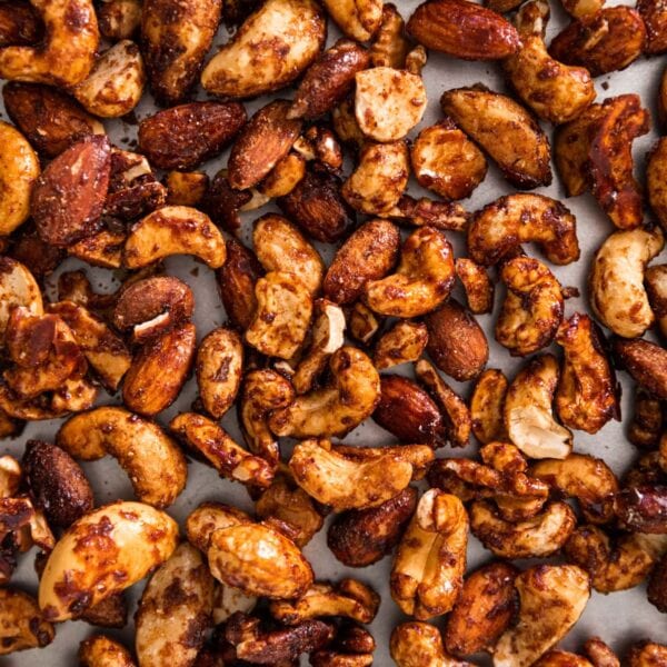 Top down of cinnamon spiced nuts sitting on silver baking pan after coming out of the oven