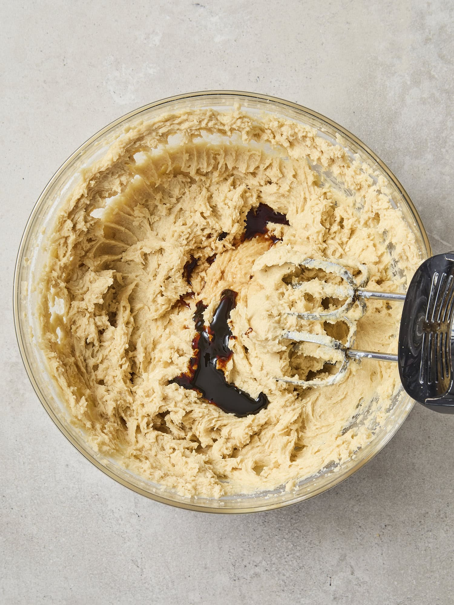 Glass bowl with dough with molasses being added.