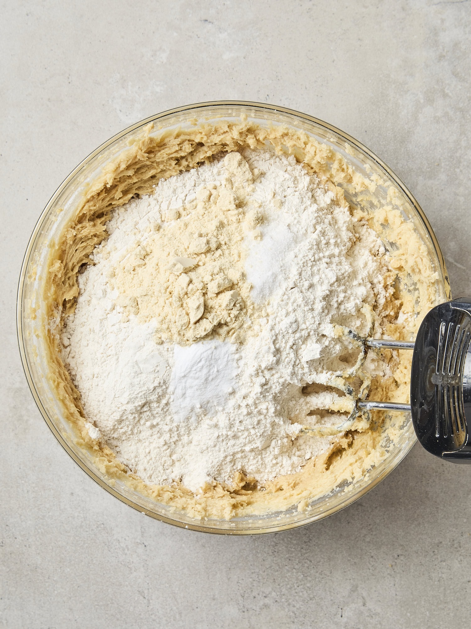 Glass bowl with flour and other dry ingredients for making cookies.