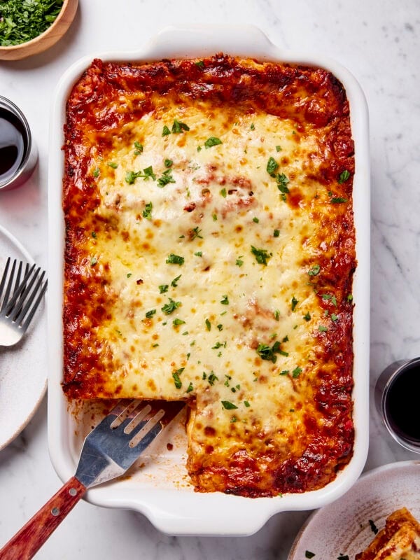 Big pan of homemade lasagna with slice missing after being scooped.