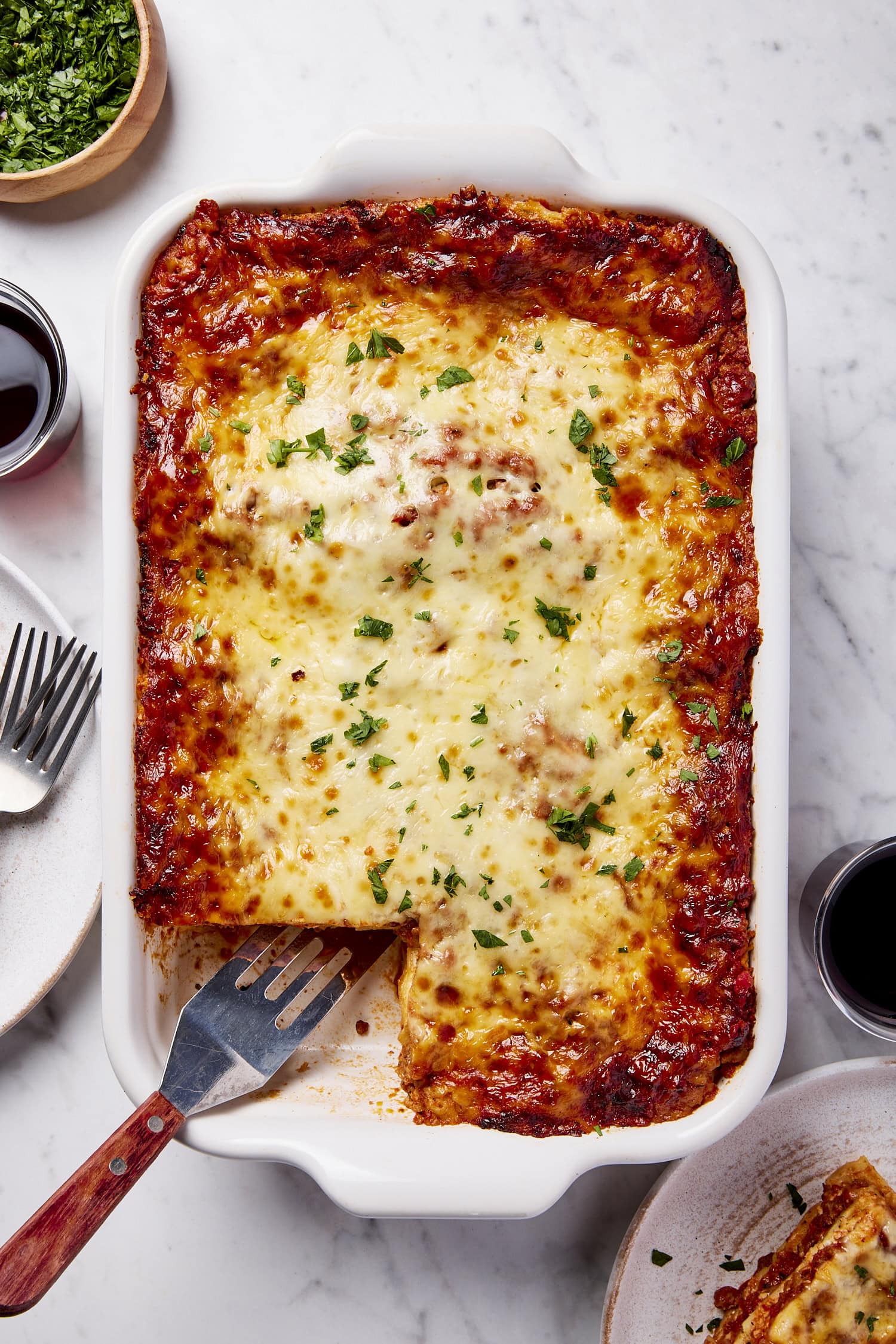 Big pan of homemade lasagna with slice missing after being scooped.