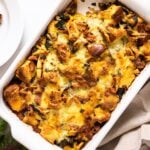 Top down view of white casserole dish filled with brown colored egg strata sitting on white countertop