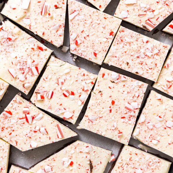 Top down view of pieces of peppermint bark sitting on metal container topped with pieces of peppermint candy