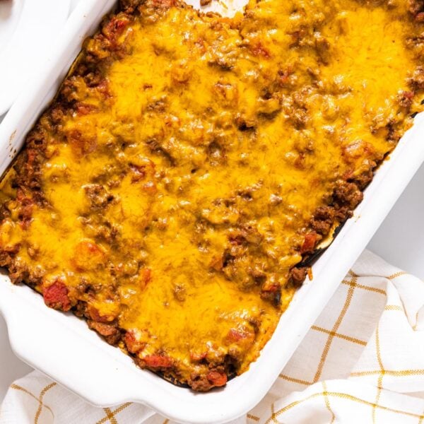 Top down view of white casserole dish filled with yellow colored cheese on top of casserole after being baked in oven