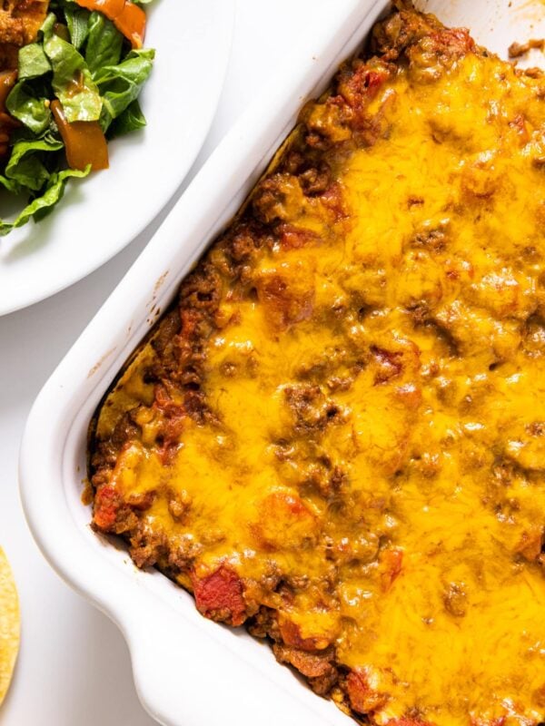 Top down view of yellow colored cheese sprinkled over the top of casserole after being baked in oven sitting on white countertop
