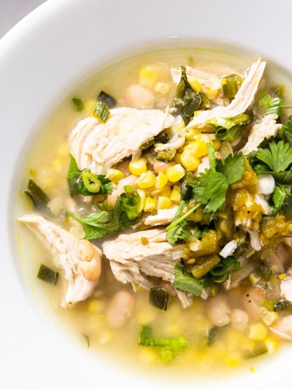 Top down view of white bowl filled with white bean chicken chili with bits of cilantro over the top