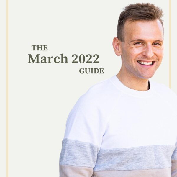 Kaleb Wyse standing in front of taupe background wearing white, gray, and tan sweater with words describing month and year on background.