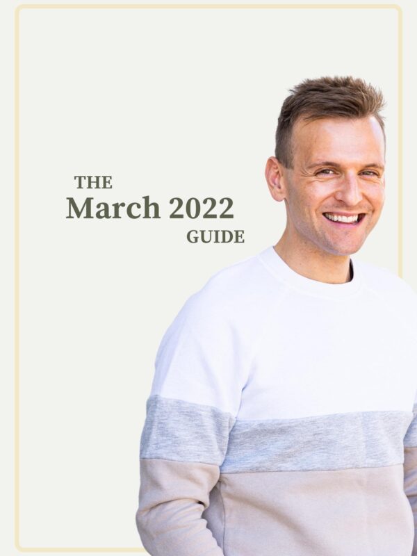 Kaleb Wyse standing in front of taupe background wearing white, gray, and tan sweater with words describing month and year on background.