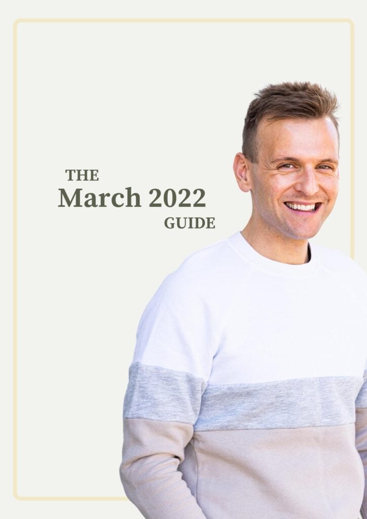 Kaleb Wyse standing in front of taupe background wearing white, gray, and tan sweater with words describing month and year on background.