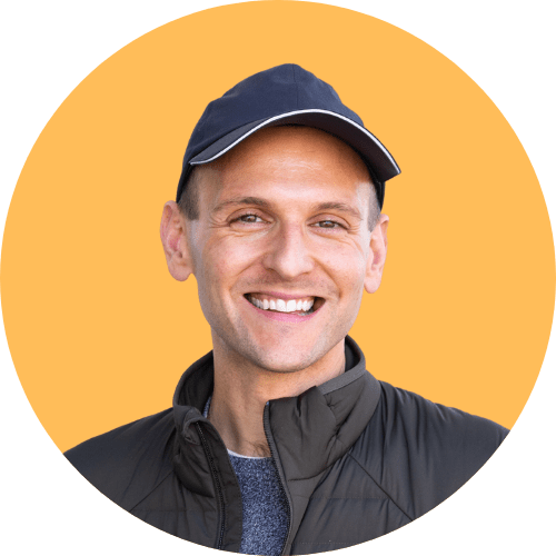 Kaleb Wyse standing in front of orange background with ball cap.