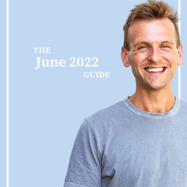 Tanned man with light blue shirt standing in front of light blue background with the words "The June 2022 Guide".