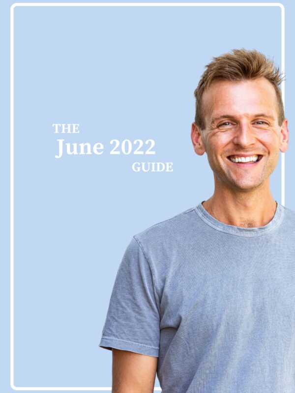 Tanned man with light blue shirt standing in front of light blue background with the words "The June 2022 Guide".