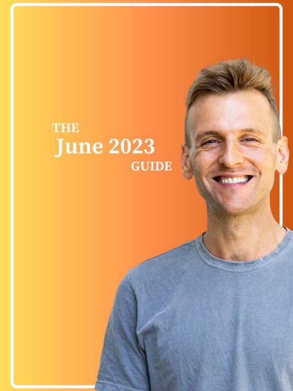 Kaleb Wyse wearing blue shirt standing in front of gradient yellow and orange background.