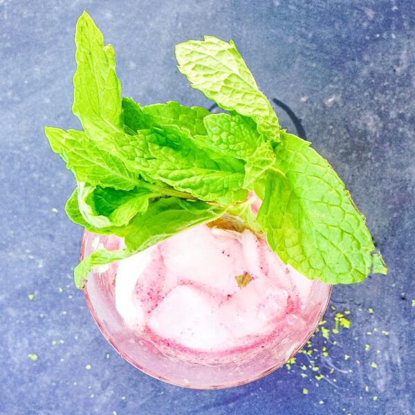 Mint sticks out the top of a mojito.