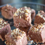 Chocolate fudge sits on a glass platter.