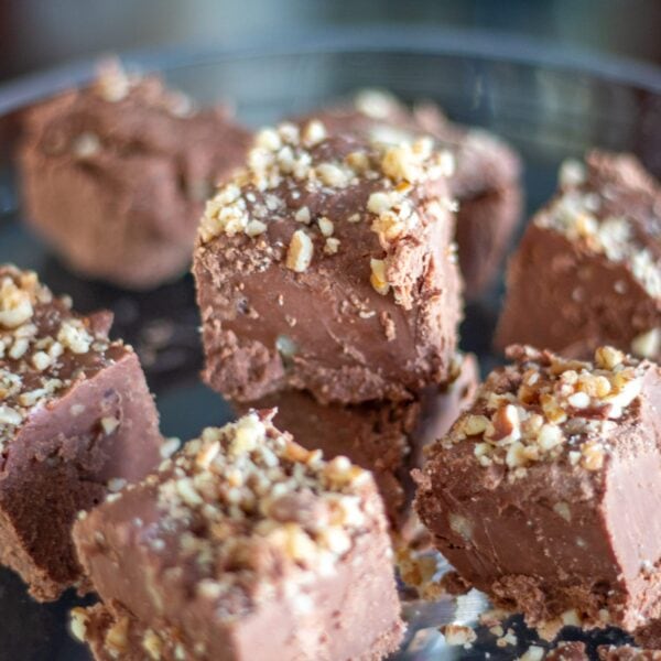 Chocolate fudge sits on a glass platter.