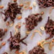 Peanut clusters and chow mein dipped in chocolate are scattered across parchment paper.