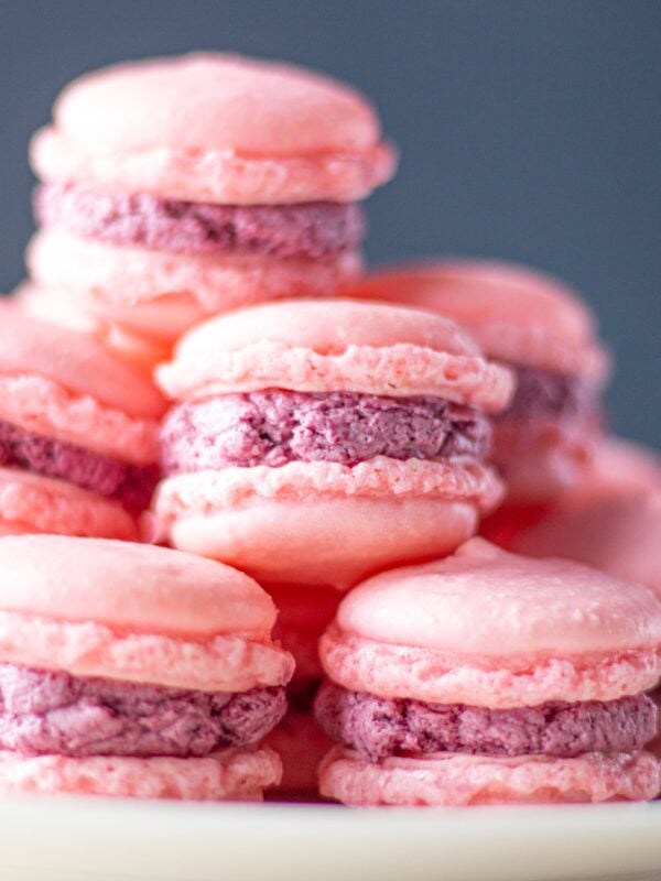 A tower of macarons rises on a plate.