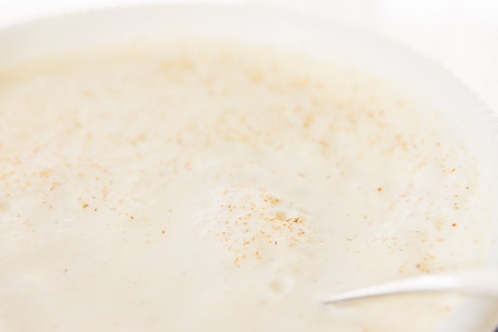 The top foam of eggnog sprinkled with spices.