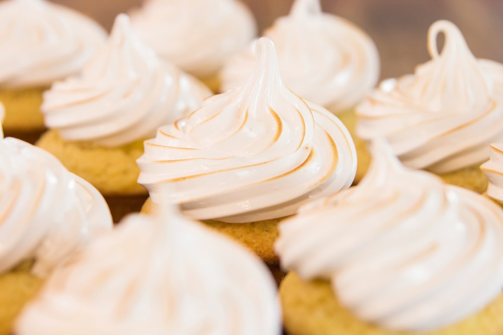 Cupcakes with meringue frosting sit in rows.