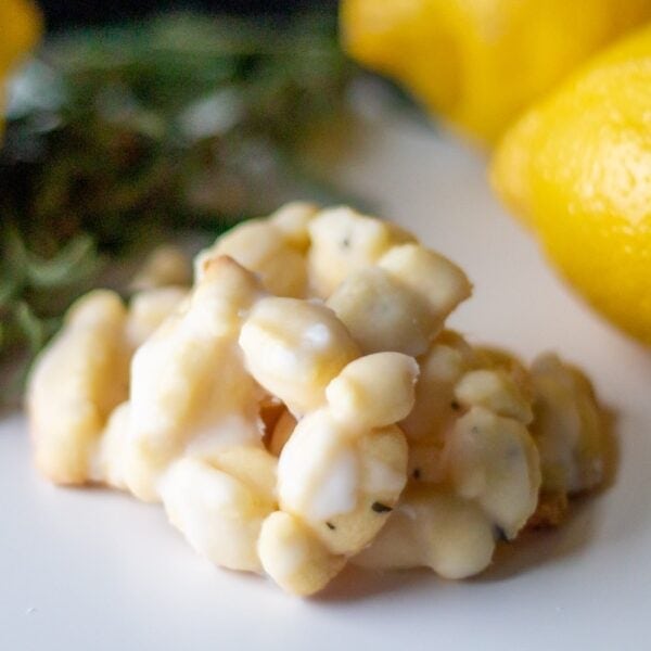 Lemon rosemary cookies lie in a pile on a table.