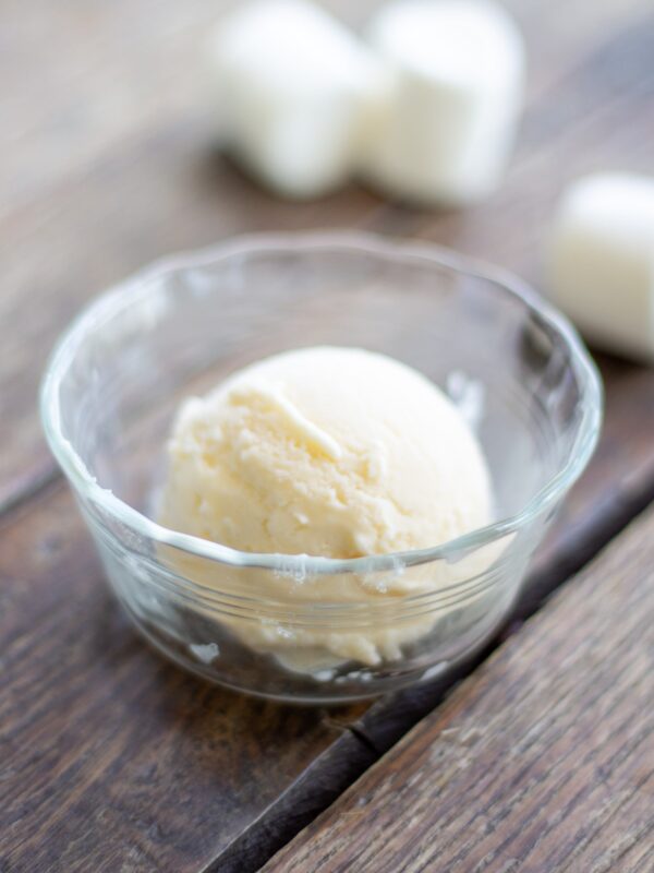 A scoop of marshmallow ice cream sits in a glass dish.